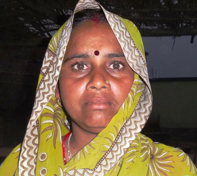 an older woman is wearing a bright green shawl