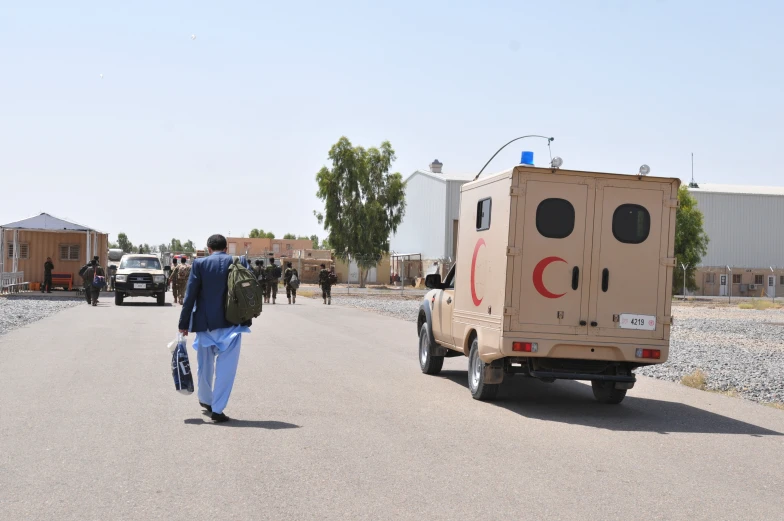 man walking in street while a soldier is looking at him