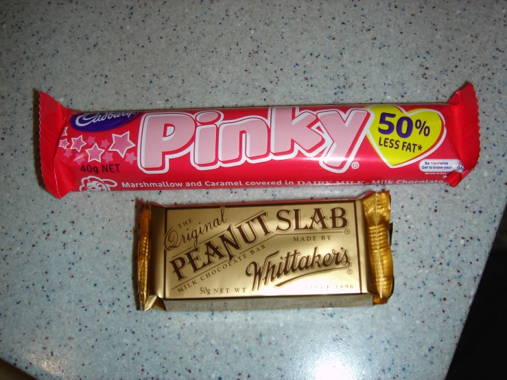a candy bar and bar of peanut er are on the counter top