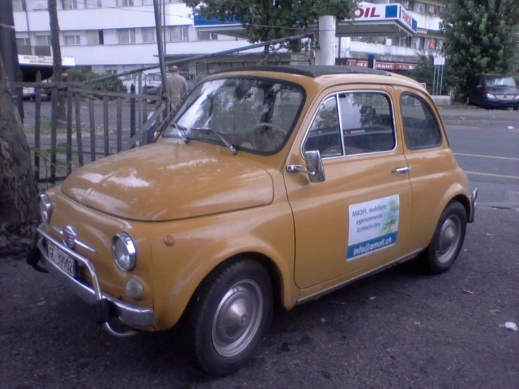 the old small car is parked on the side of the road