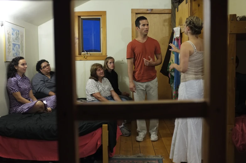 a group of people sitting down in a room with a woman standing up