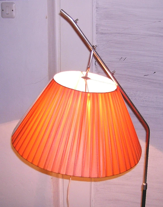 an orange lamp with a light on the floor