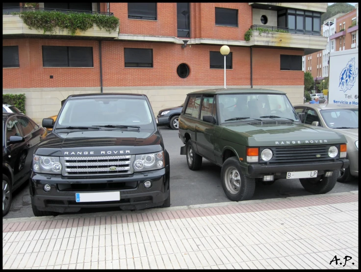 two army green and black land rover cars parked together