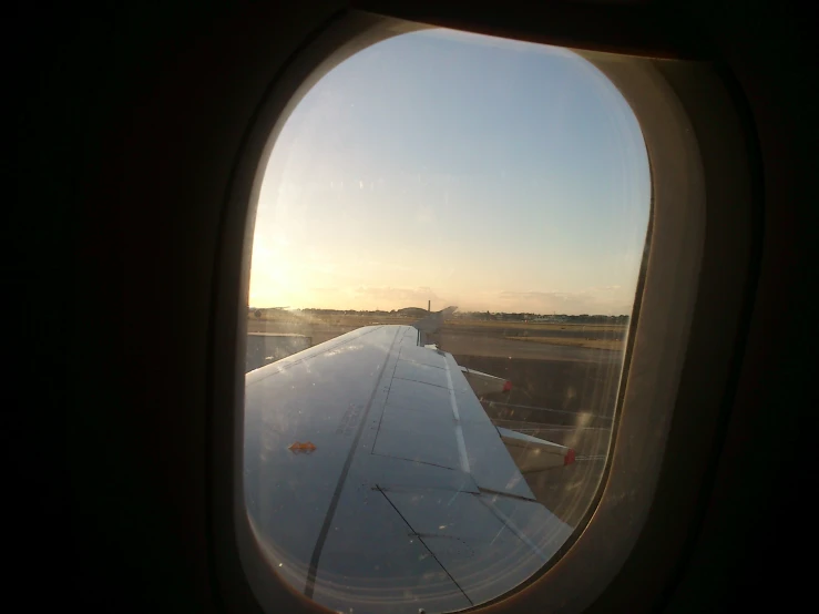 a window view of an airport runway from a passenger airplane