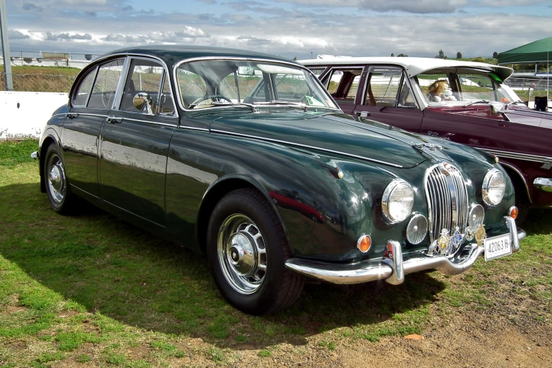 classic cars are parked next to each other on the grass