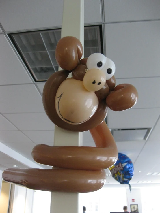 an inflatable monkey hanging on a pole is hanging from the ceiling