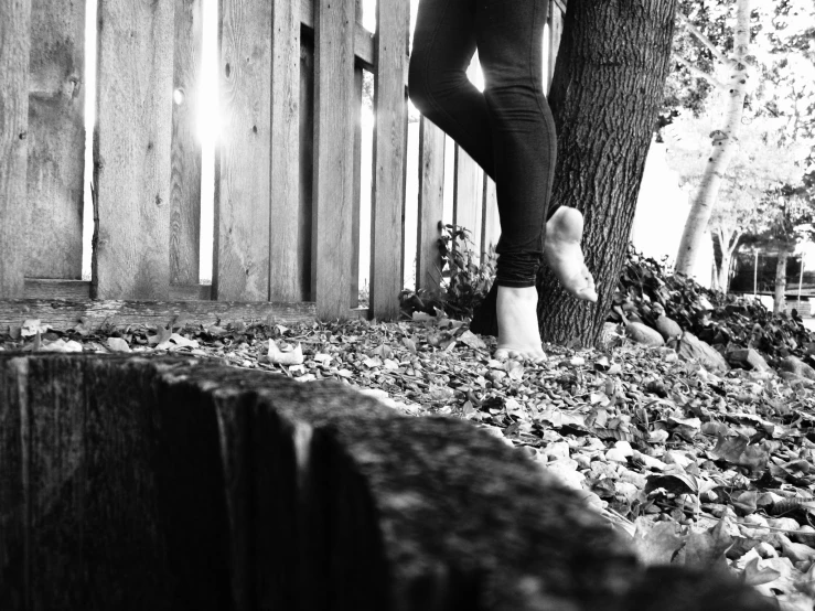 the feet of a man walking next to a tree