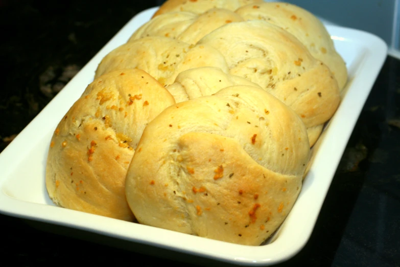 a white platter of bread with one piece cut out