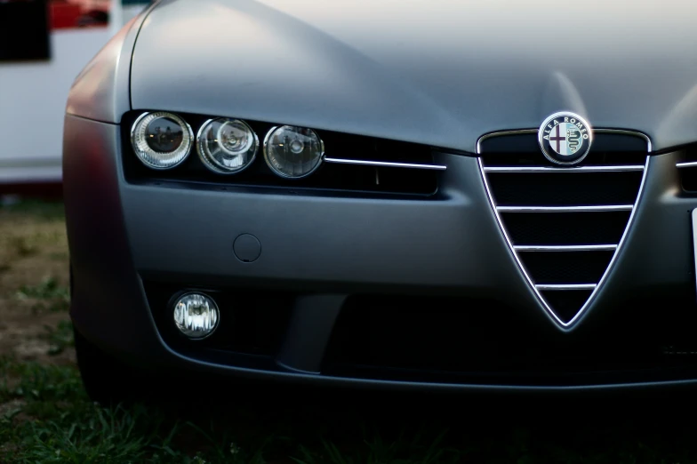 the front grille of an automobile parked in a grassy area