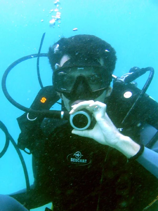 a scuba man taking pos with a camera in the water