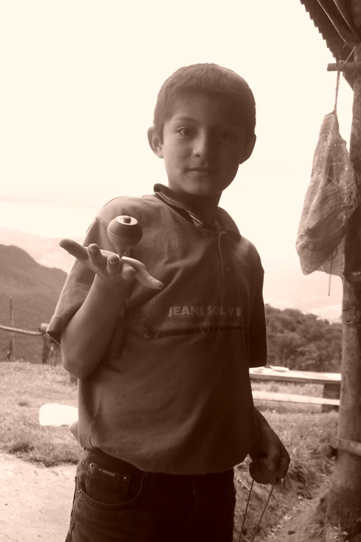 a boy stands with an object on the shoulder