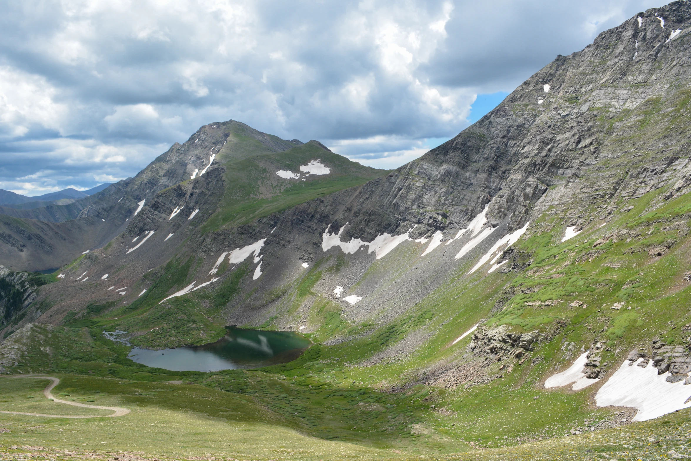 the mountains have a small lake on one side