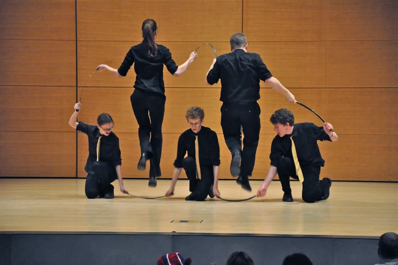 four people stand on top of a stage with poles