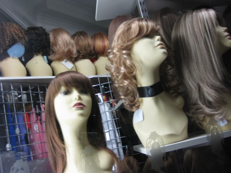 mannequins with various types and sizes of hair in a display case