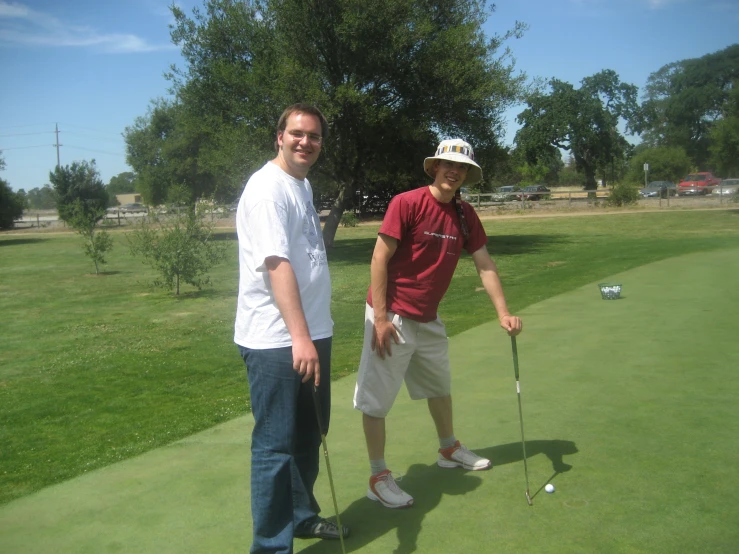 two men are standing on a green playing golf