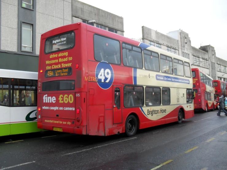 red double decker buses are sitting on the side of the street