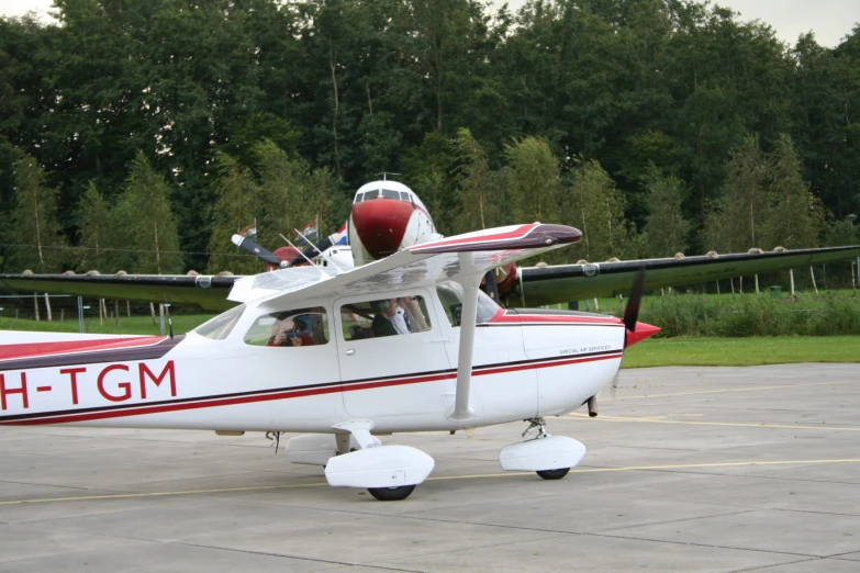 small red and white plane sitting on the tarmac