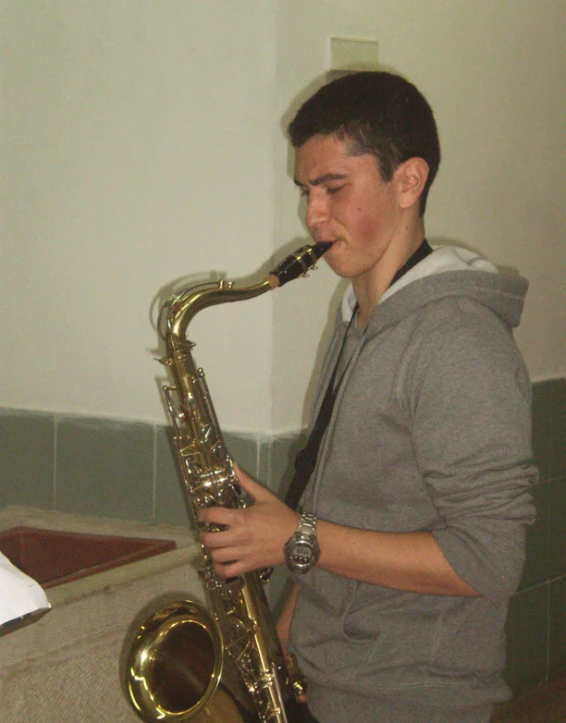 a man playing the saxophone in a bathroom