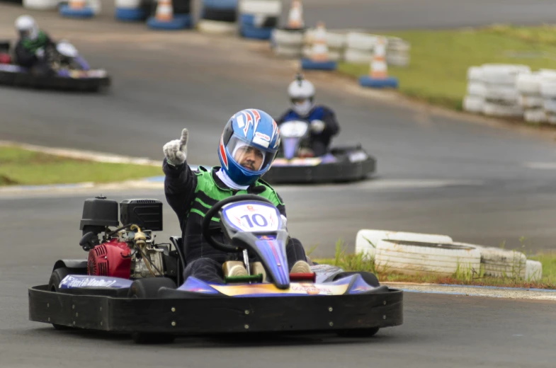 the man has got an exciting time riding his go - cart around a track