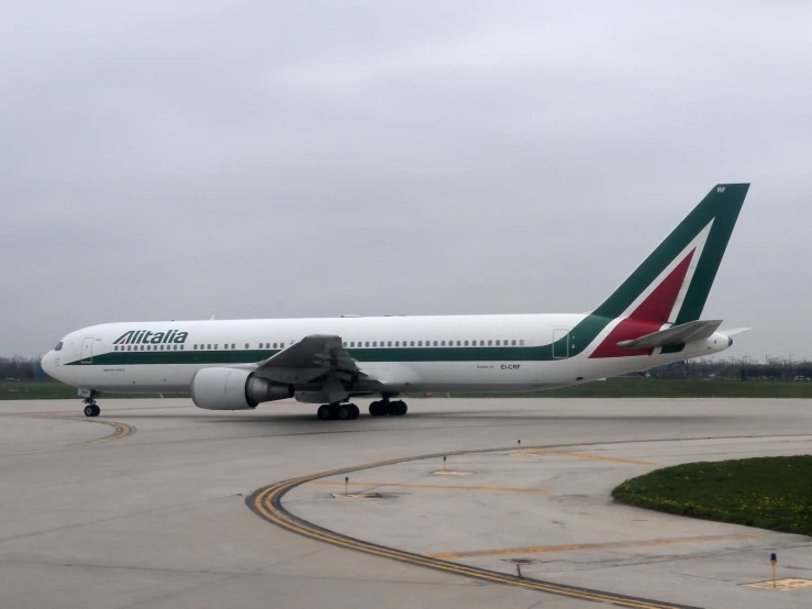 a commercial airplane parked on a runway on a cloudy day