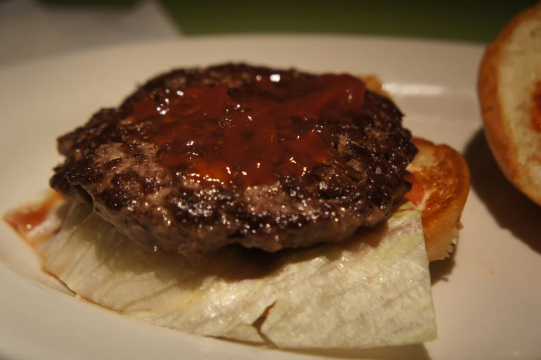 the burger is on a white plate and the other side is sliced bread