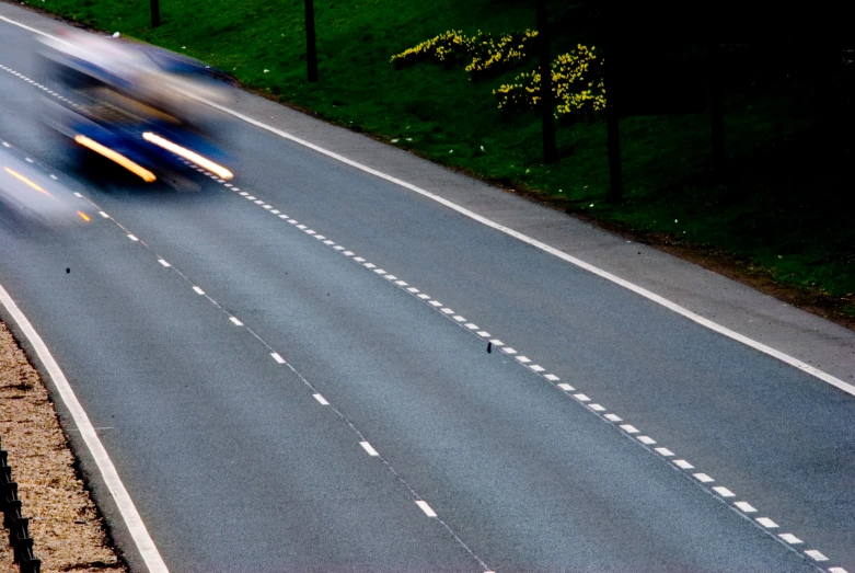 three cars driving on a highway with motion blurs