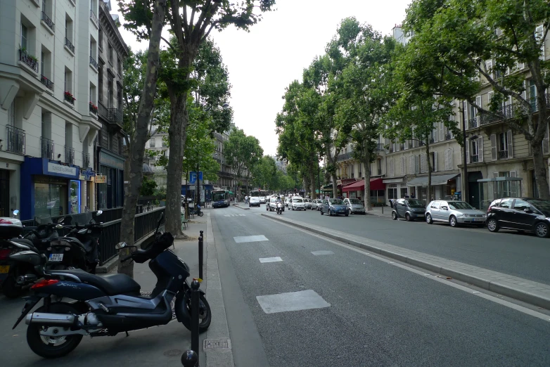 a motorcycle parked on the side of a street next to tall buildings