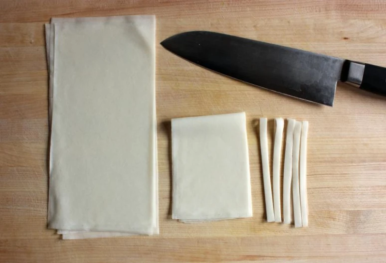 a knife, knife blade, and paper sitting on top of a table