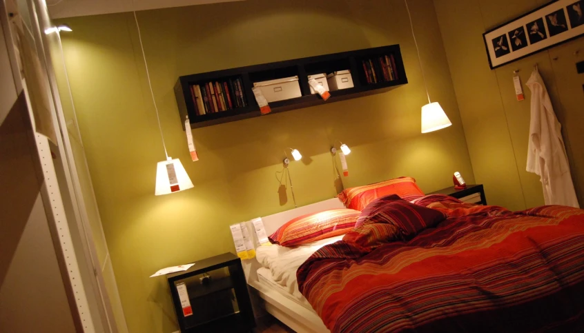 the bed is neatly made with three lights on either side of the headboard