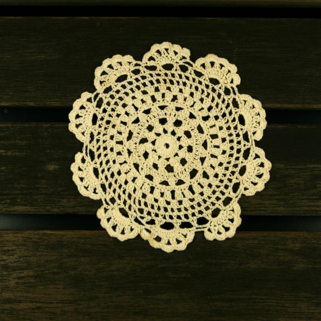 the table is made out of wood and has a doily on it