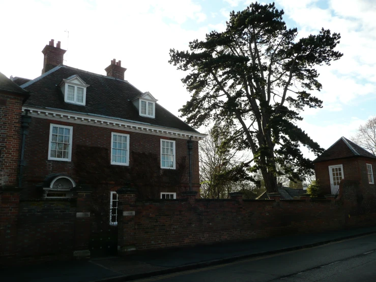 a large tree in front of a brick building