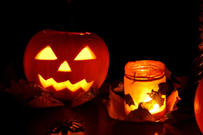 two pumpkins and a candle are sitting on a table