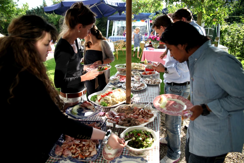 many people are gathering around food to eat