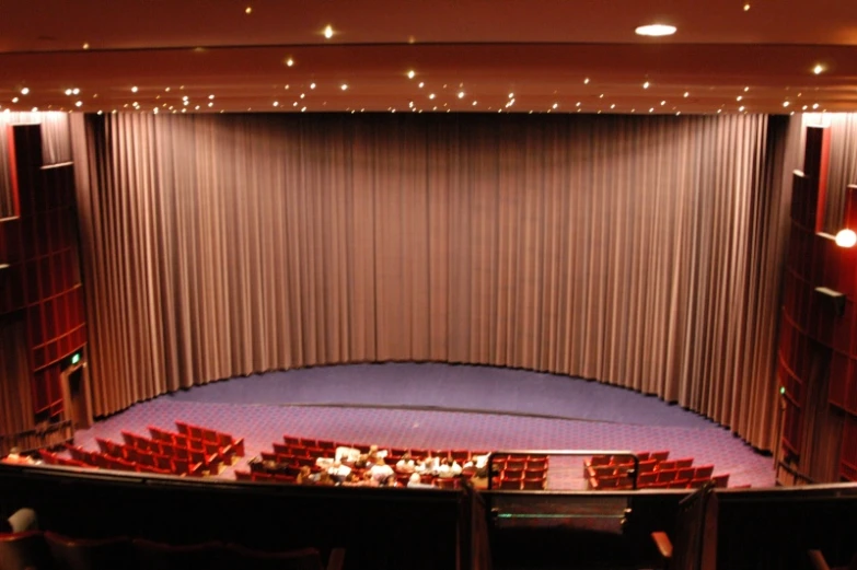 a large auditorium with a stage and a row of chairs