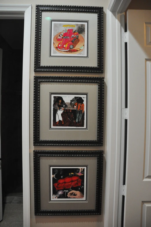 a fireplace with four pictures hanging from it