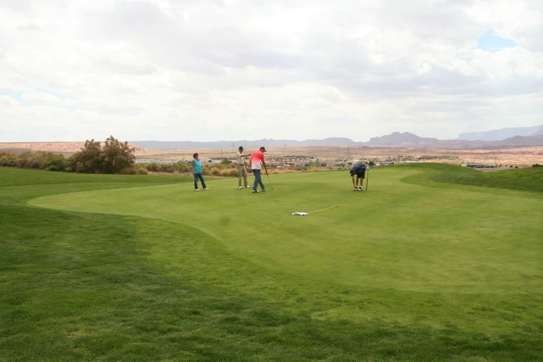 people in the grass golf match on a very cloudy day