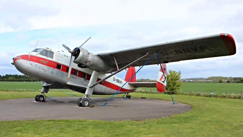 a small propeller plane parked next to a field