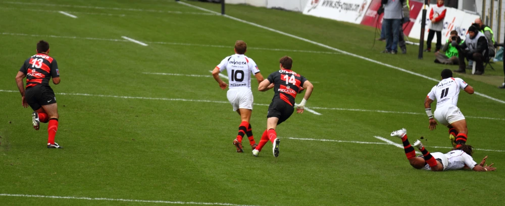 men playing a game on the field running after a soccer ball