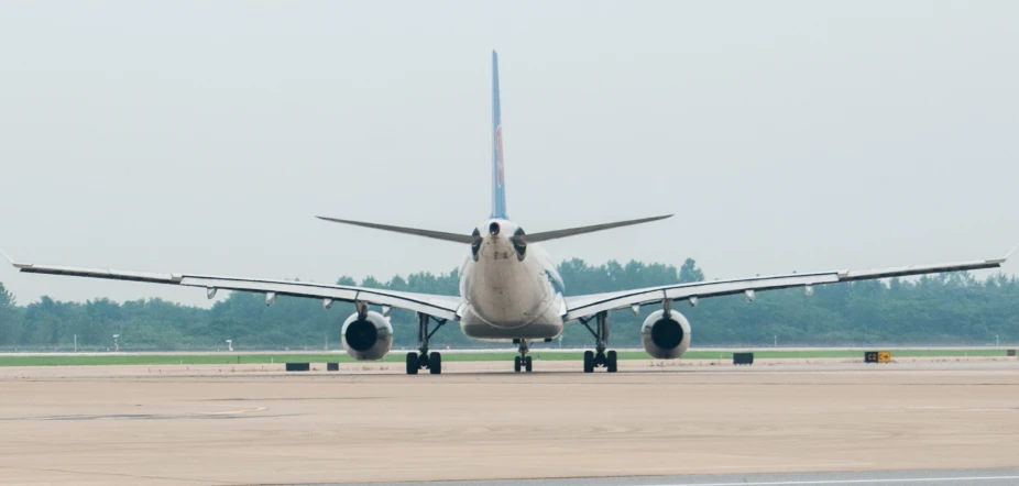 a white jet airliner on runway at airport