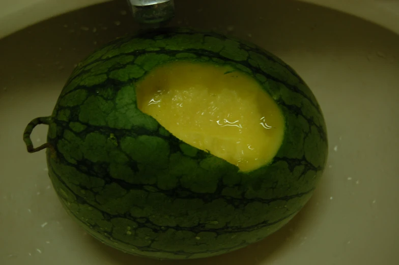 a watermelon cut open and filled with yellow liquid