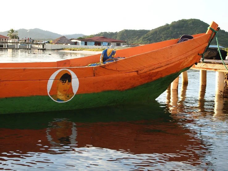 an orange boat sits in a body of water