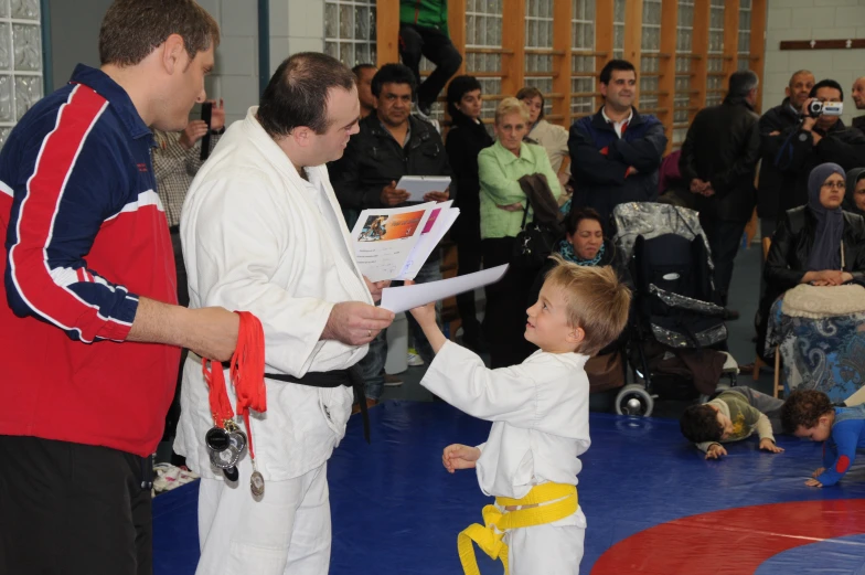 two men are shaking hands next to a child