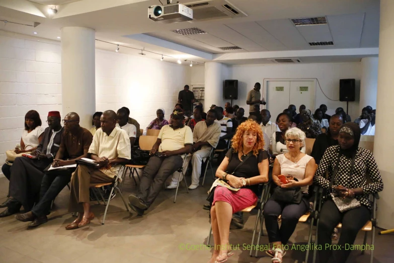 a group of people in chairs with some listening