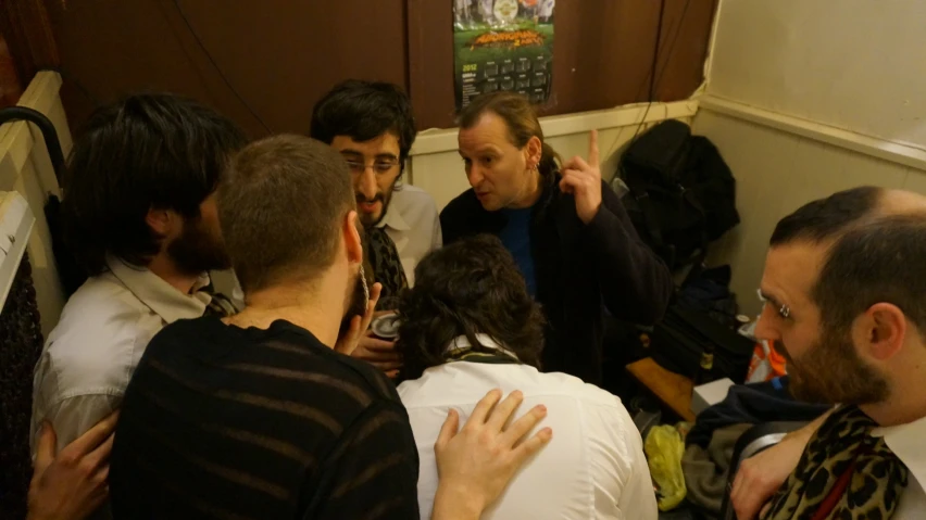 a group of men standing around each other in a hallway