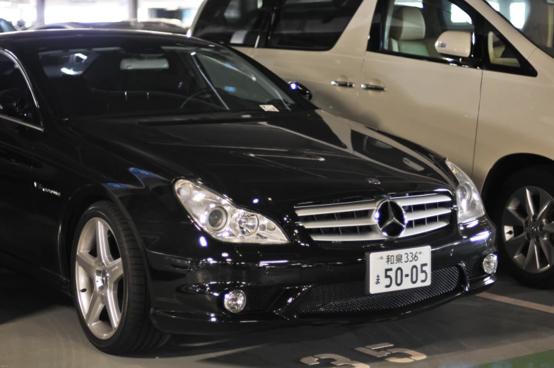 two black cars in a parking garage with two one white