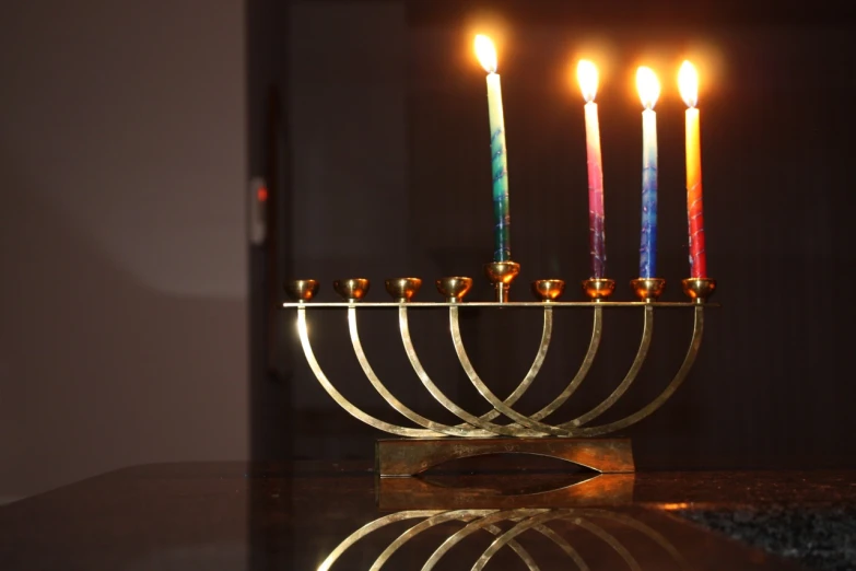 a gold hanukkah with four lit candles
