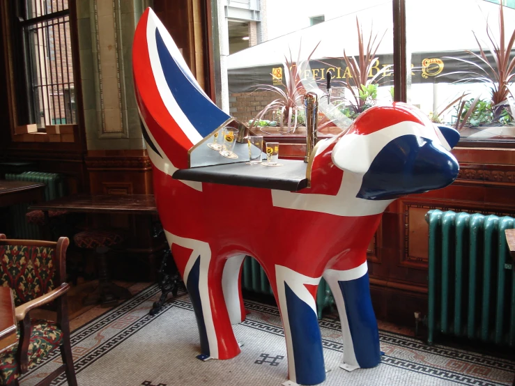 a british flag painted horse that is next to a table