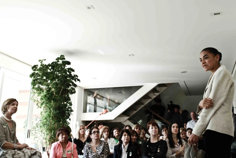 a woman standing at the front of a crowd next to another person