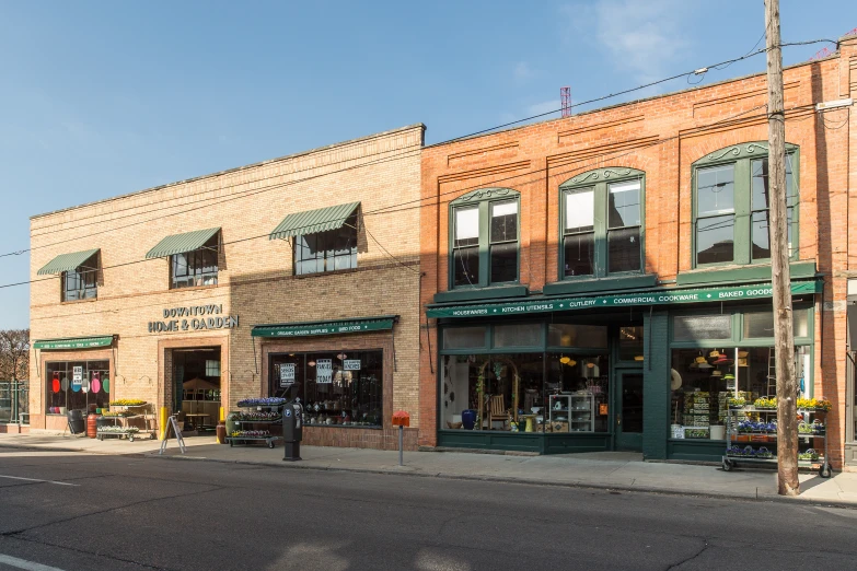 a brown brick building and green awnings on street