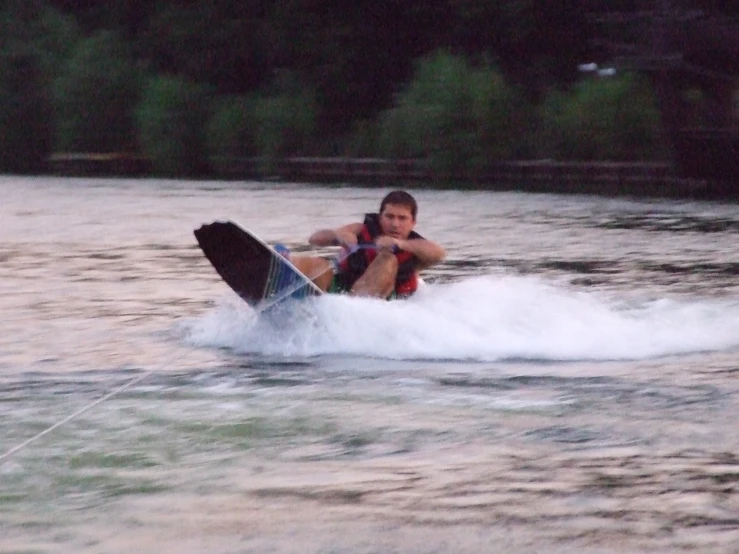 a boy on the water in a board being pulled